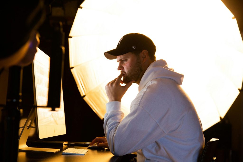 Contemplative man working on computer with professional studio lighting setup